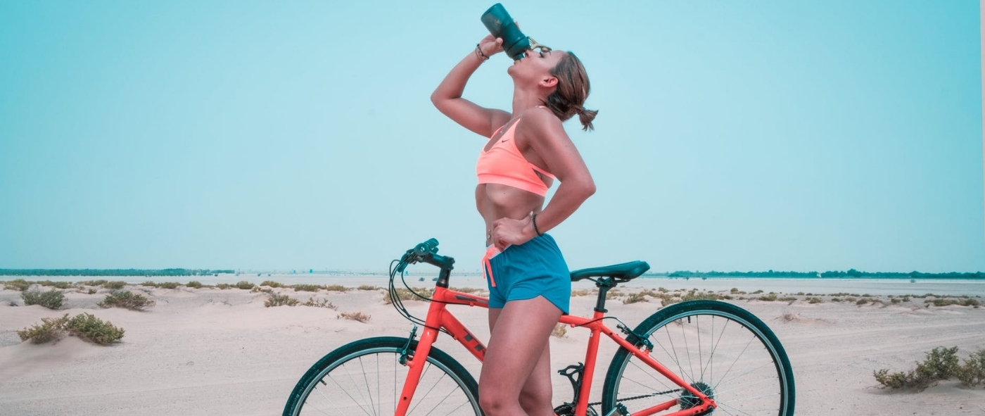 Kobieta pijąca elektrolity po treningu na rowerze