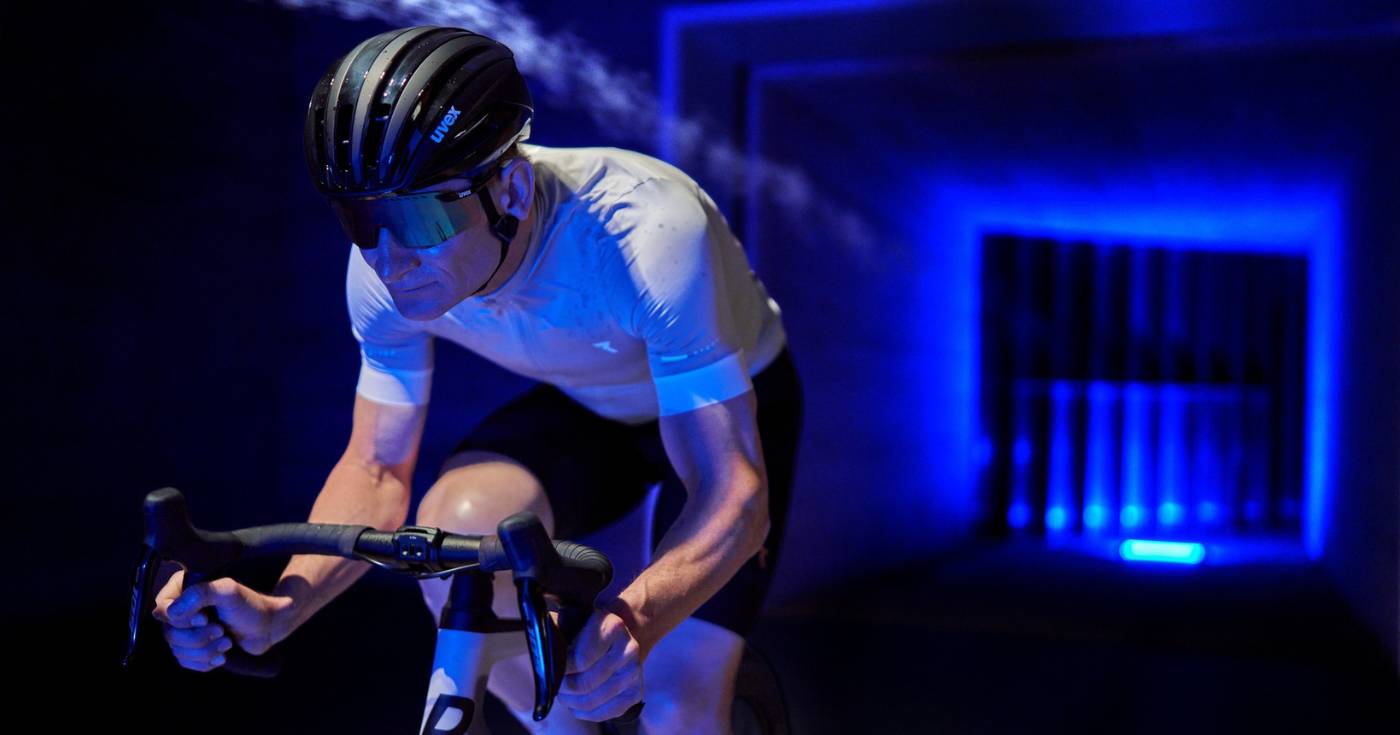 Kolarz testujący aerodynamikę z okularami rowerowymi w tunelu aerodynamicznym