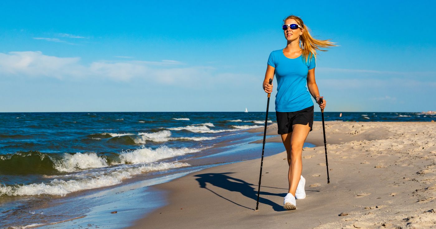 Kobieta uprawiająca Nordic Walking na plaży